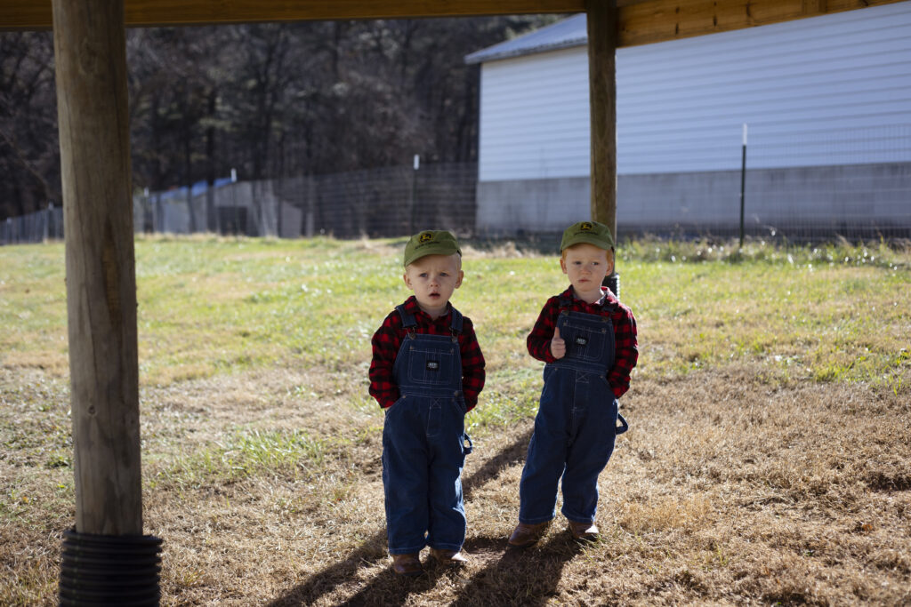 Two Young farmers standing under a shade structure