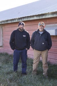 Farmer Focus Farmers, father & son, standing outside in the outdoor access area