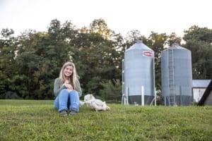 Lacey Farmer Focus Farmer Sitting on Hill with chickens